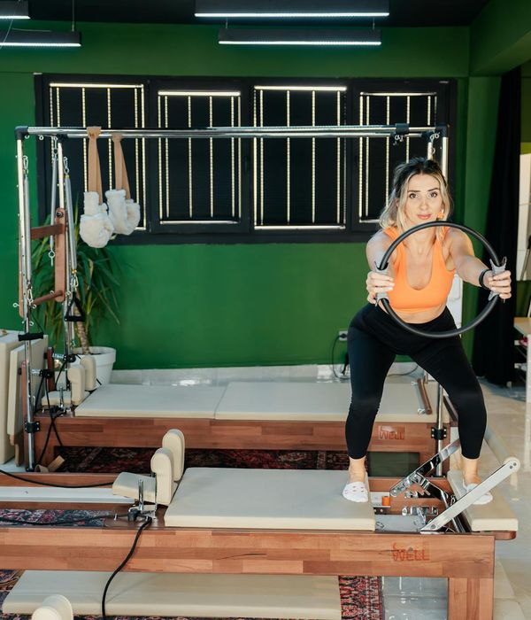 Woman performing a dynamic cardio exercise in a modern studio.